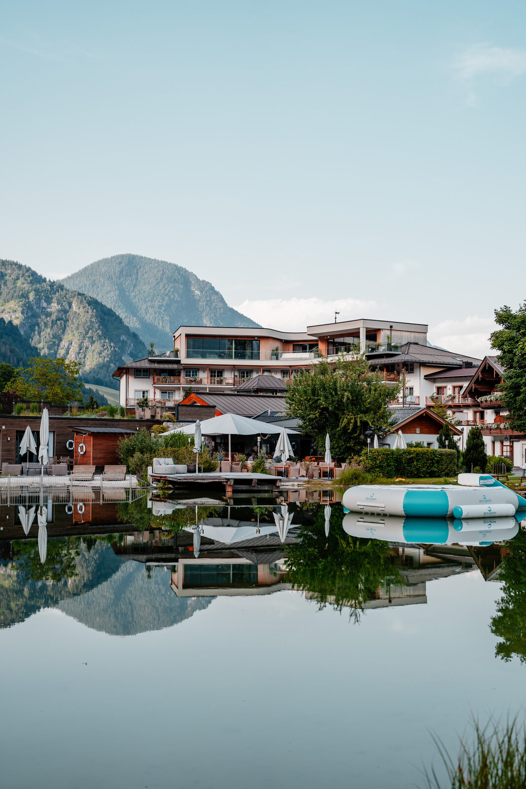 POST Family Resort reflected in the bathing lake, the Sonntagshorn rising behind.